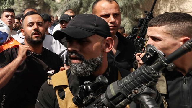 EDITORS NOTE: Graphic content / TOPSHOT - Mourners and armed militants carry the body of Islam Khamayseh, a local commander of Al-Quds Brigade, the armed wing of militant group Palestinian Islamic Jihad, killed in an overnight Israeli strike on the occupied West Bank Jenin refugee camp, during his funeral on May 18, 2024. (Photo by Zain JAAFAR / AFP)