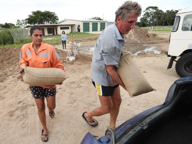 Bowen locals, including Rena Singh and Jim Gaffney, fill sand bags on Sunday. Picture: Lyndon Mechielsen