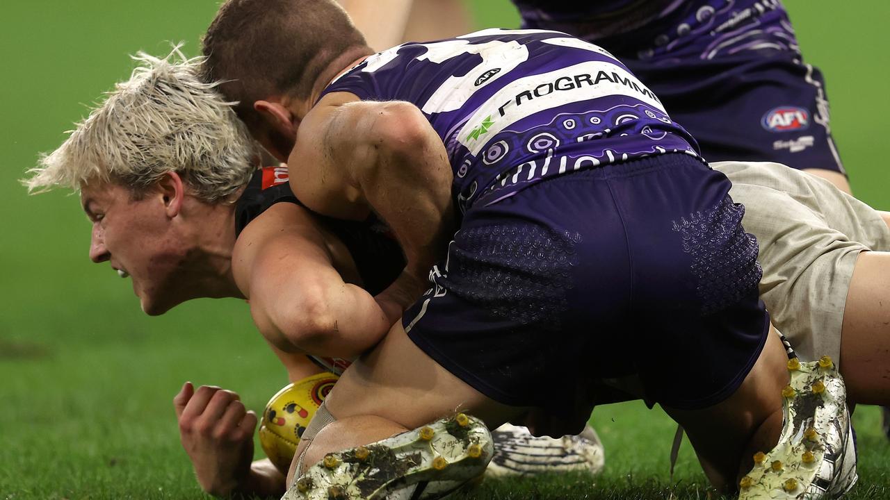 Sam Switkowski grabs hold of Jack Ginnivan’s wrist during Sunday night’s game. Picture: Paul Kane/Getty Images