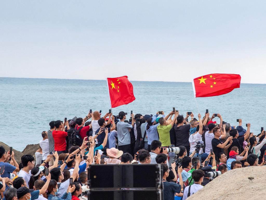 People watch a Long March 5B rocket, which launched last week to deliver the first module for China’s new Tianhe space station, lifting off on April 29. Picture: STR/AFP.