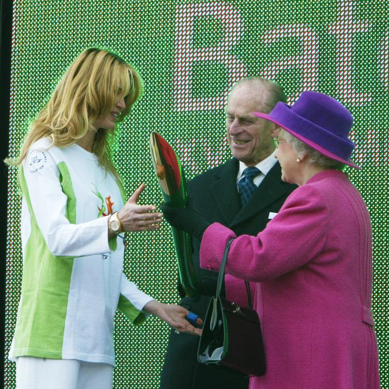 The Queen presents the Commonwealth Games Relay Baton to Elle Macpherson at Buckingham Palace. Picture: David Caird