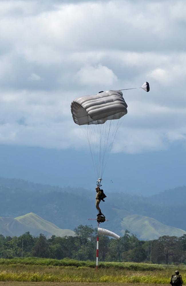 An Australian Army soldier from the Australian Defence Force Parachuting School prepares to land at Nadzab, Papua New Guinea, after conducting a military free-fall parachute jump to commemorate the 80th anniversary of the Nadzab airborne assault in World War II.