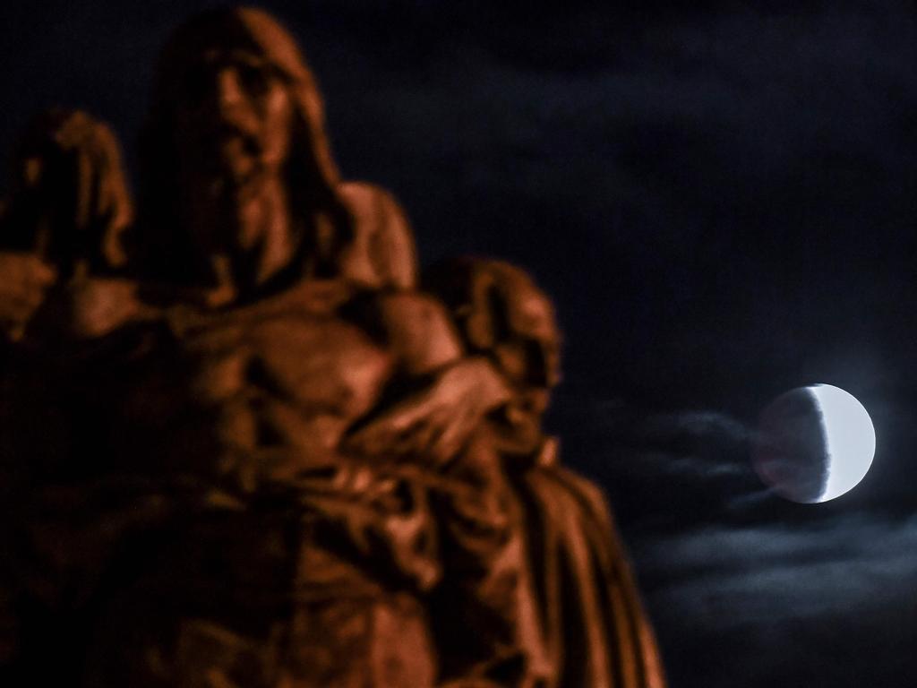 The moon is seen behind the Independence Monument during a partial lunar eclipse in Sao Paulo, Brazil, on July 16, 2019. (Photo by NELSON ALMEIDA / AFP)