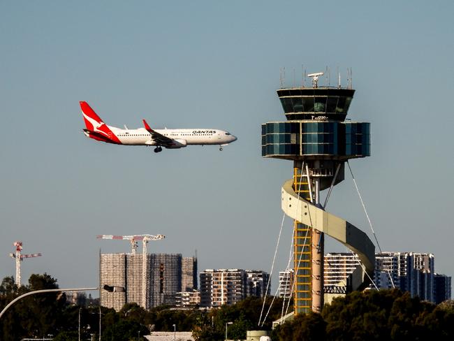 A Qantas B737-838 plane, registration VH-VXU, coming into land on the third runway of Sydney Kingsford-Smith Airport as flight QF579 from Hamilton Island.  In the foreground is the air traffic control tower.  This image was taken from Kyeemagh Avenue, Kyeemagh on a sunny winter afternoon on 10 June 2023.Escape 13 October 2024Doc updatePhoto - iStock