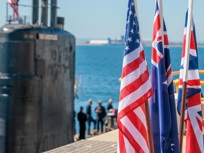 National flags of the USA, Australia and Great Britain are seen in front of the USS Asheville, a Los Angeles-class nuclear powered fast attack submarine, at HMAS Stirling, Western Australia on Tuesday, March 14, 2023. Picture: NCA NewsWire / pool / Richard Wainwright