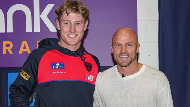 Nathan Jones presenting Melbourne footballer Jacob van Rooyen with his footy jumper. Picture: Supplied