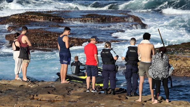 Police, surf rescue and members of the public look on in the wake of yesterday’s shark attack. Picture: Richard Dobson