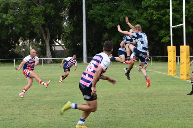 Moranbah's Matthew Smith kicks the ball as Slade Point's Travis Joblin makes a leap for it in the Slade Point Slashers v Moranbah Bulls in Mackay Rugby Union Round 4 Seniors A-Grade Anzac Day clash at Cathy Freeman Oval in Slade Point. Saturday, April 23, 2022. Picture: Max O'Driscoll