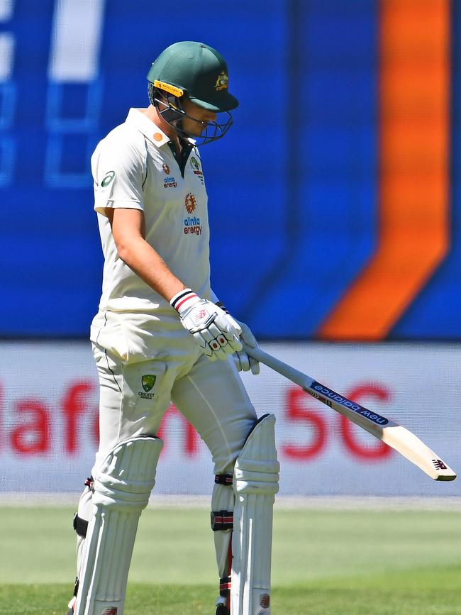 Australia's batsman Pat Cummins walks back to the pavilion after his dismissal today.