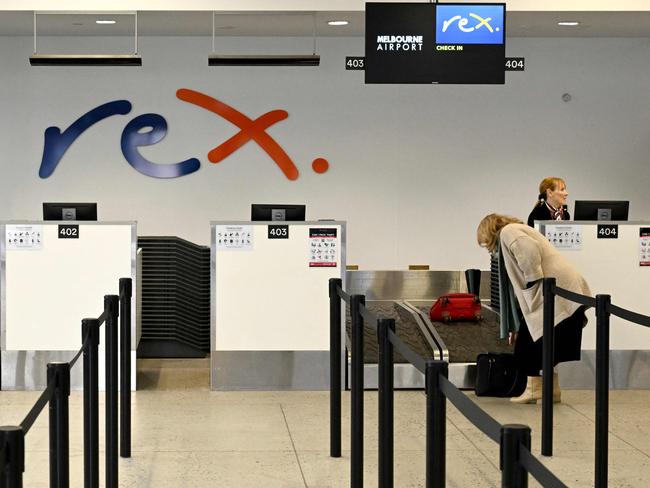 A passenger checks in for a Rex Airlines flight at Melbourne's Tullamarine Airport on July 31, 2024. The Australian regional airline Rex cancelled flights as it entered voluntary administration on July 31, leaving the fate of the country's third-largest carrier in serious doubt. (Photo by William WEST / AFP)