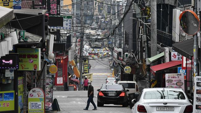 A man wearing a face mask walks in the popular night-life district of Itaewon in Seoul. Picture: AFP.