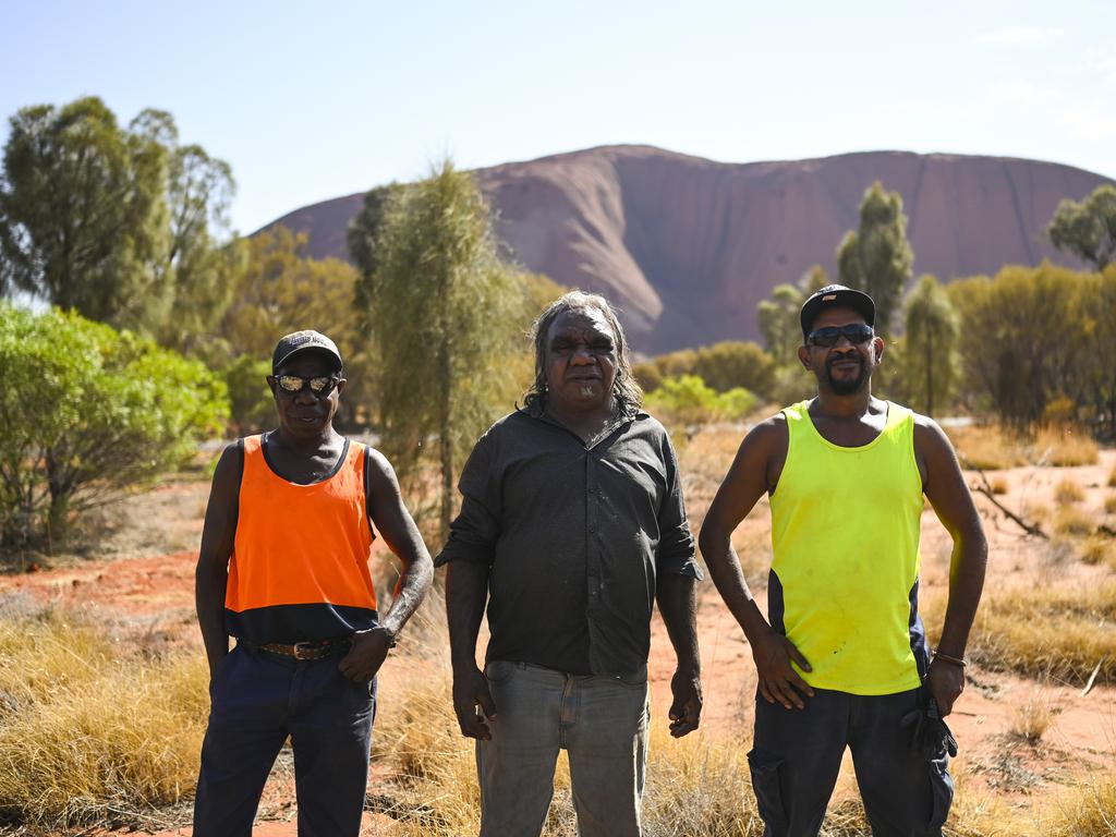 Mutitjulu Community residents and Council workers Robert David, Xavier Kitson and Kevon Cooley near Uluru. Picture: Image/Lukas Coch