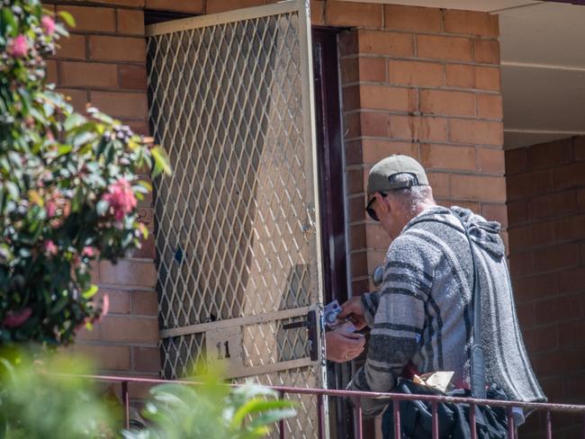 A man gets out cash ready to pass through the cut-out hole in the door last month. Picture: Jason Edwards