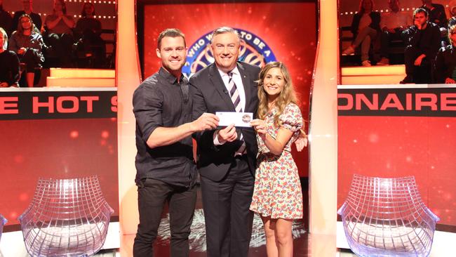 Charlie and Liv Gard holding the $50,000 cheque with host Eddie McGuire. Picture: CHANNEL 9