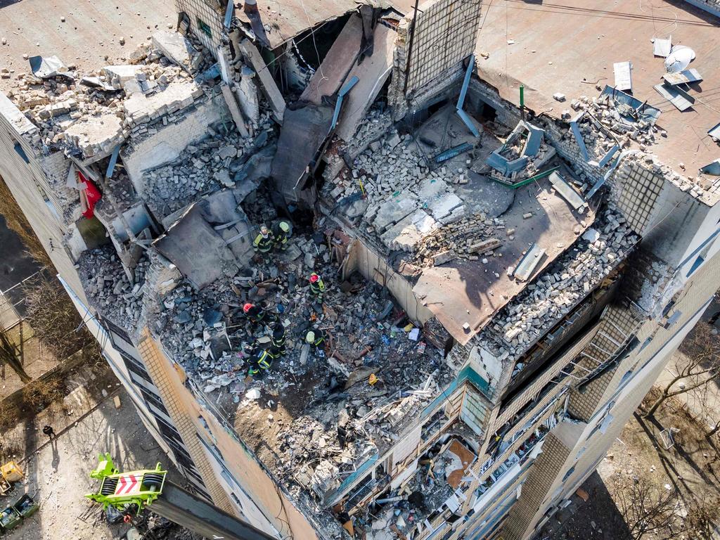 Firemen working in the rubble of a residential building which was hit by the debris from a downed rocket in Kyiv. Picture: AFP