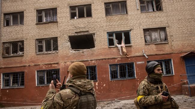 Members of the Ukrainian military look at damaged caused by overnight Russian shelling of a residential building. Picture: Getty Images.