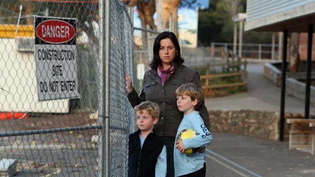 Leesa Snookes, with sons Campbell, 5, and Will, 7, at the Berlin Wall that divides Ocean Grove Primary School in Victoria. Picture: Stuart McEvoy