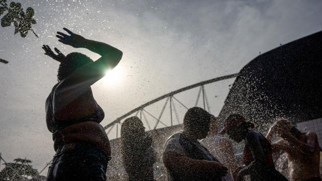 Fans were seen trying to cool themselves off outside the Nilton Santos Olympic Stadium before Swift's concert. Photo by Tercio TEIXEIRA / AFP.