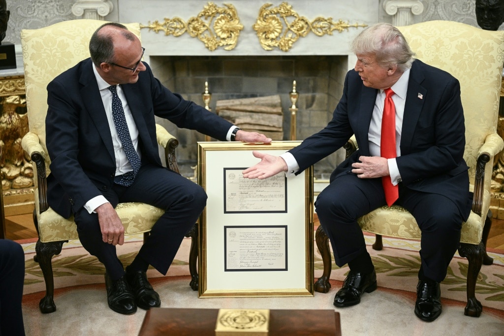 German Chancellor Friedrich Merz presents US President Donald Trump with what Merz said was the birth certificate of Trump's grandfather, who was born in 1869, during a bilateral meeting in the Oval Office of the White House in Washington, DC, on June 5, 2025.  A month into his job, the conservative Merz, 69, will try to build a rapport with the mercurial Trump as he seeks to maintain good ties with the country he considers post-war Germany's 