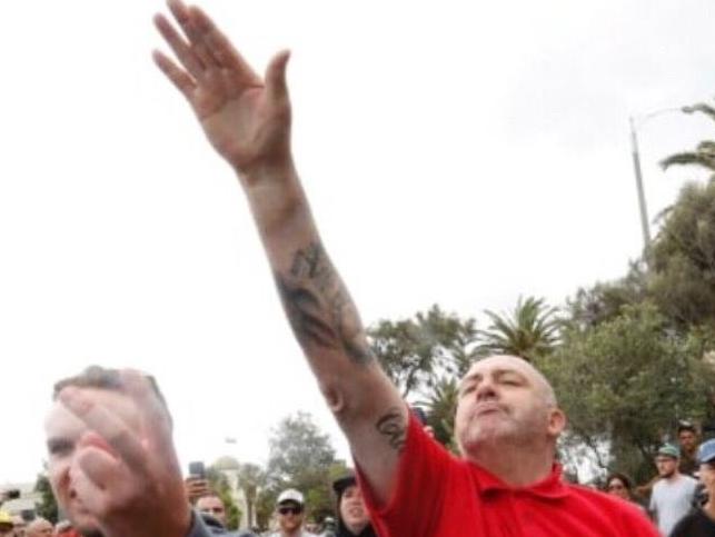 A right-wing protester gives a Nazi salute at a 'patriots' rally at St Kilda Beach.