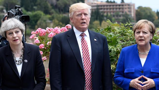 Britain's Prime Minister Theresa May, US President Donald Trump and German Chancellor Angela Merkel arrive to watch an Italian flying squadron during the Summit of the Heads of State and of Government of the G7. Picture: AFP.