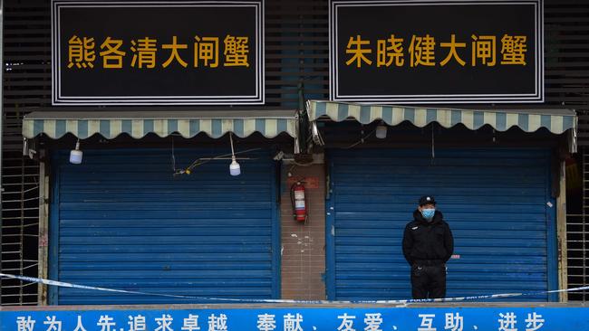 A security guard stands outside the Huanan Seafood Wholesale Market where the coronavirus was detected in Wuhan on January 24. Picture: Hector Retamal / AFP