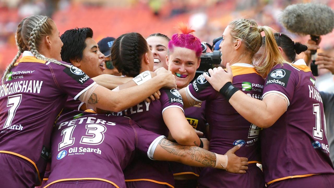 Chelsea Baker (centre) of the Broncos celebrates scoring a try with teammates,