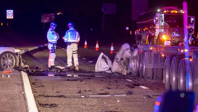 Car parts are strewn across the road.