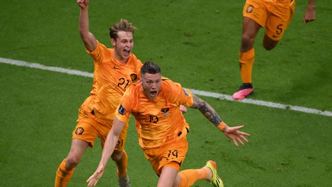 Netherlands' forward #19 Wout Weghorst (front) celebrates his equaliser against Argentina. (Photo by FRANCK FIFE / AFP)