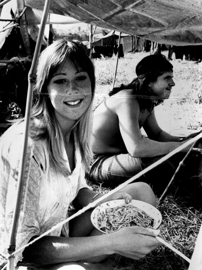 Two people sit under a tarp, enjoying a meal at the Aquarius Festival at Nimbin in 1973. Picture: News Corp NSW