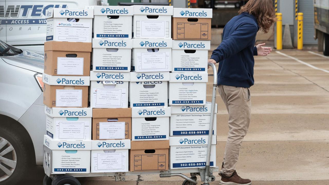 A person transports documents for the trial where Elon Musk will testify over his $50 billion pay package as CEO of Tesla. Picture: Oliver Contreras/AFP