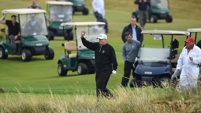 US President Donald Trump waves while playing a round of golf at Trump Turnberry Luxury Collection Resort in Scotland. Photo: Getty Images