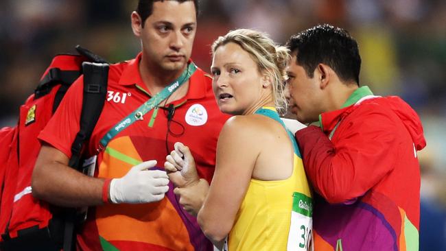 Kim Mickle of Australia is assisted by medical staff after being injured during the Women's Javelin Throw Qualifying Round on Day 11 of the Rio 2016 Olympic Games.