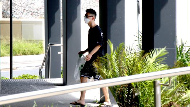 A resident walks into the Unilodge building wearing a face mask. Picture:AAPimage/David Clark