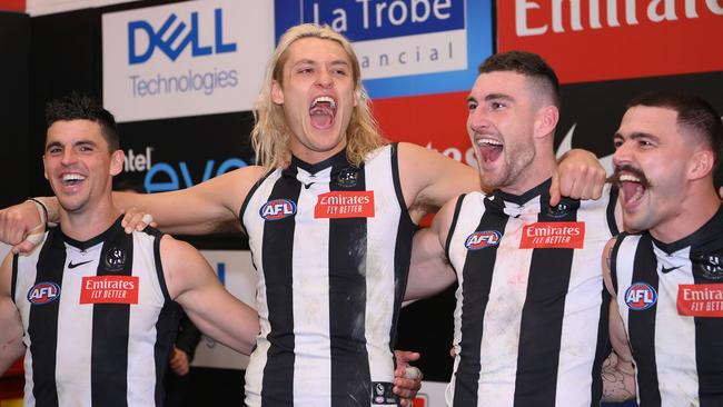 Collingwood players celebrate their win over Melbourne.