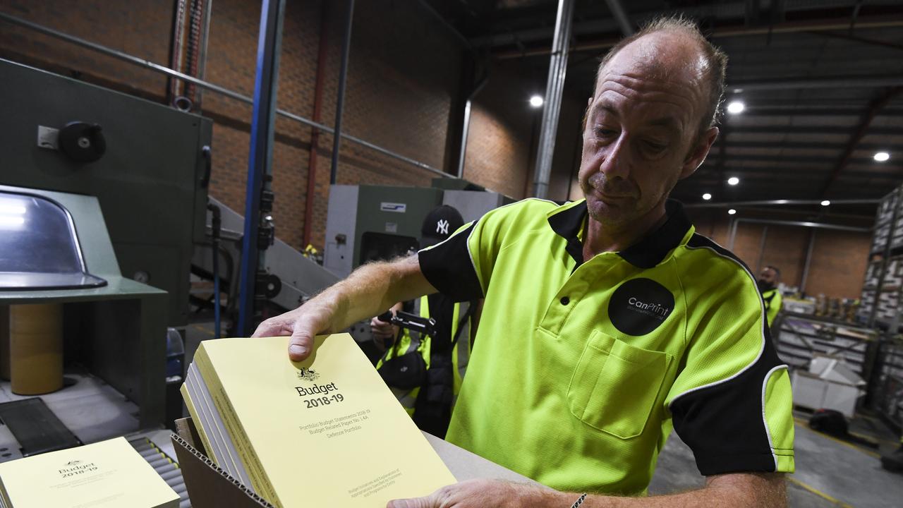 A print worker handling a stack of the 2018-19 Budget papers in Canberra. Picture: AAP Image/Lukas Coch.