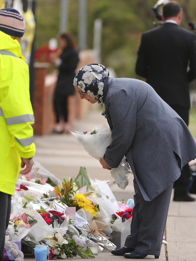 Family members leave flowers at the front gate of the school today. Picture: John Grainger