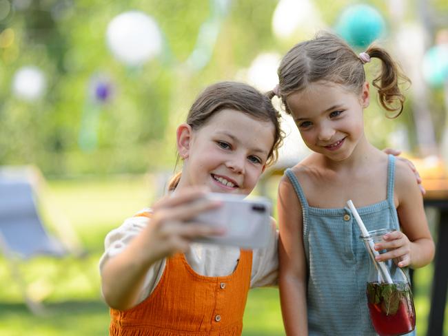 Kids, Children, Mocktail, mocktails.  Cousins taking a selfie at a family garden party. Family reunion at a garden barbecue party. Picture: istock