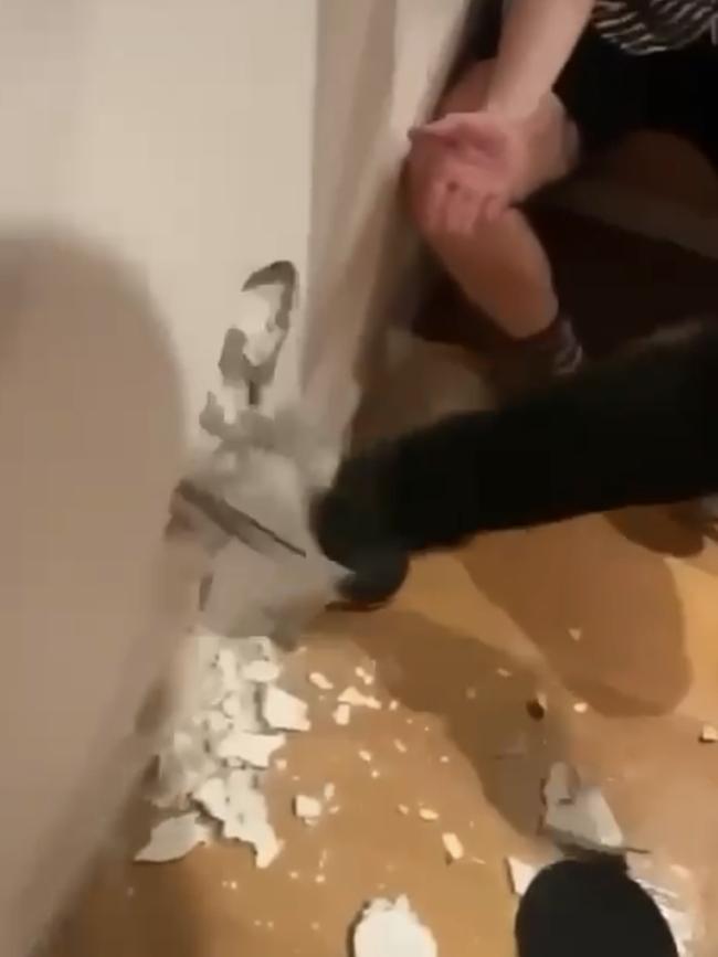 Grabs from a video showing troubled Melbourne footballer Clayton Oliver kicking a hole in a wall.