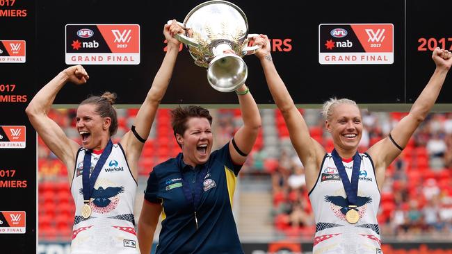 Chelsea Randall, Bec Goddard and Erin Phillips hold the AFLW premiership cup aloft.
