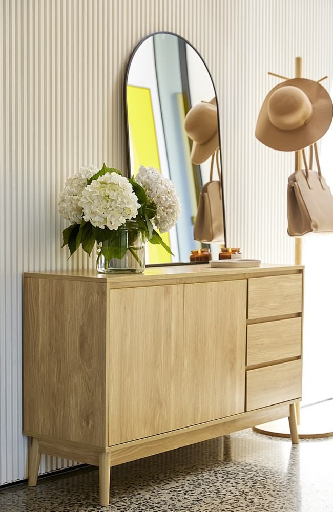 Light wood finishes and sleek black metal dominate the new range. Pictured: arch mirror, $40, buffet unit, $149, and coat stand, $19. Picture: Kmart