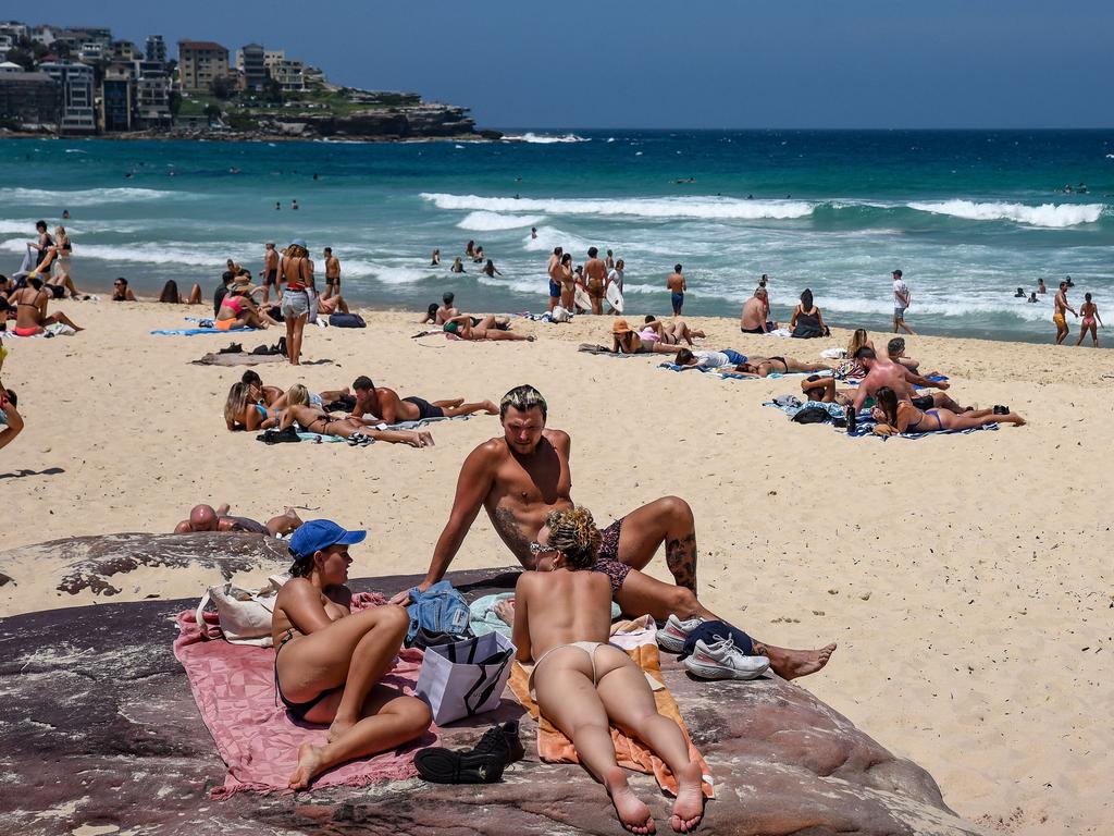 People are seen at Bondi Beach on a hot day despite the marine warning of a Tsunami. Picture: NCA NewsWire / Flavio Brancaleone