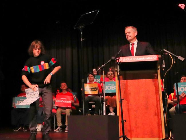 Bill Shorten looks unimpressed as a protester runs on stage during his big announcement at a rally in Box Hill, Melbourne. Picture Kym Smith