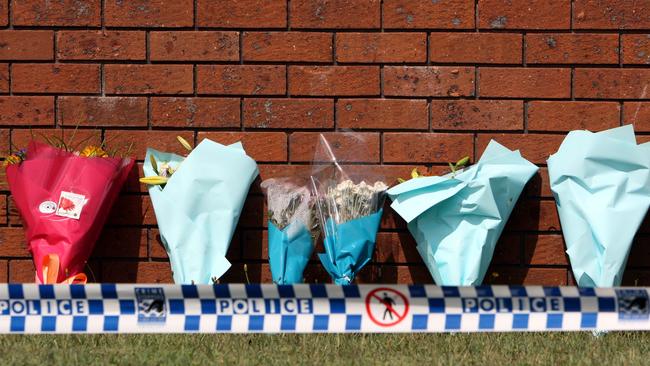 Flowers stand against the brick fence of the house in Macquarie Grove, Caves Beach, where Stacey McMaugh and partner Robert Pashkuss were murdered on Sunday January 6, 2008.