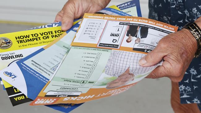 A voter with a handful of how to vote cards at the Australian Electoral Commission pre polling centre in the seat of Leichhardt in Cairns ahead of the federal election. Picture: Brendan Radke