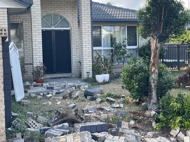 A Runaway Bay home was badly damaged when one of the cars crashed through the front retaining wall.