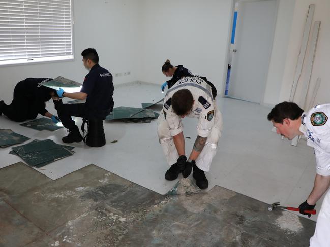 Forensic officers pull up tiles at the Juno Pde house. Picture: NSW Police