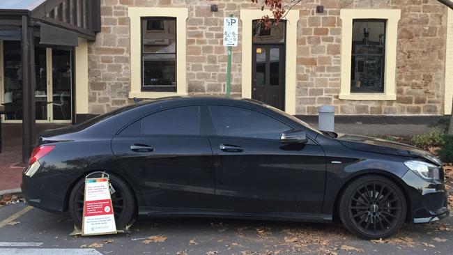 A car clamped on the corner of Hutt and Halifax streets, in the city, after failure to pay parking fines.