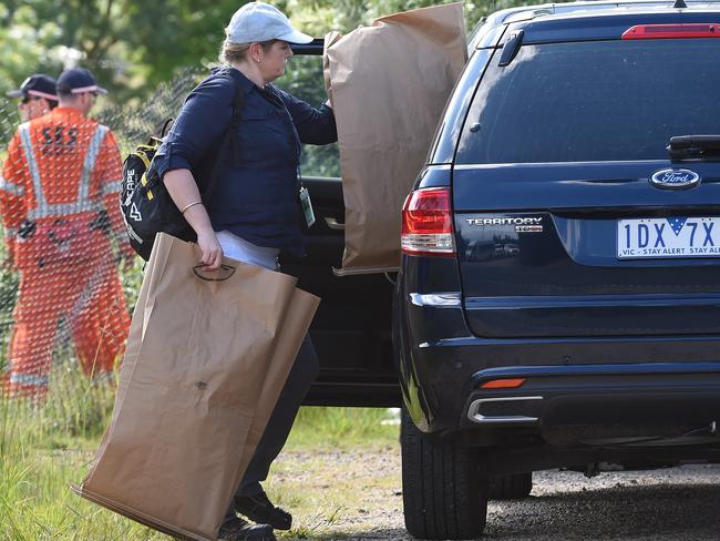 An police officer removes evidence from the scene. Picture: Lawrence Pinder