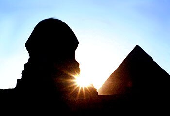 Night falls ... the sun sets behind the Sphinx and pyramids at Giza, Egypt / Reuters